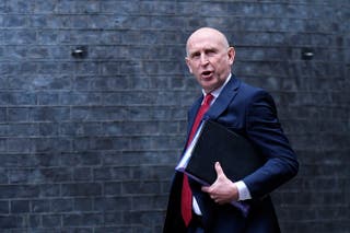 O secretário de Defesa, John Healy, participa de uma reunião de gabinete em Downing Street